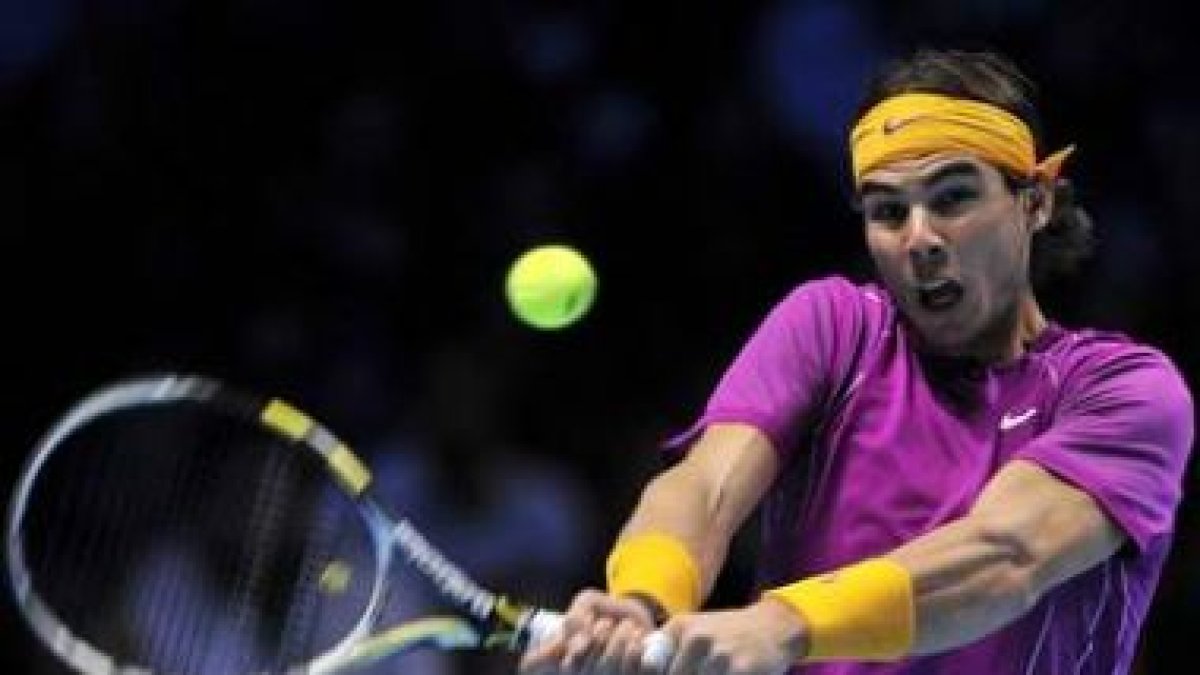 El tenista español Rafael Nadal responde una bola ante el serbio Novak Djokovic.