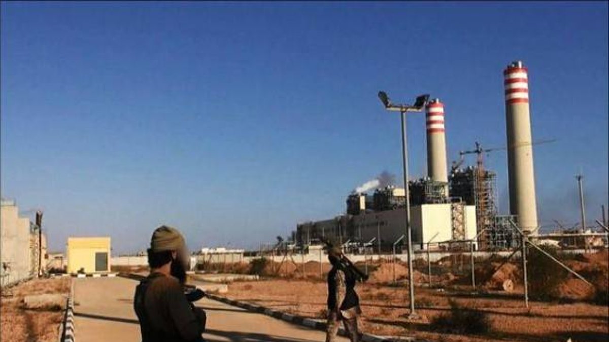 Dos yihadistas frente a la central eléctrica tomada en Sirte.