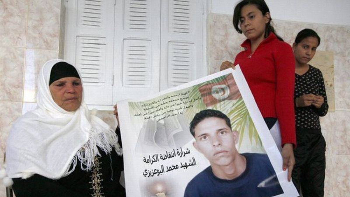 La madre de Mohamed Bouazizi, el joven que se quemó a lo bonzo en Túnez en diciembre del 2010 en protesta por la situación de su país y que ahora ha sido galardonado con el premio Sájararov, sostiene una pancarta con la imagen de su hijo, el pasado 22 de