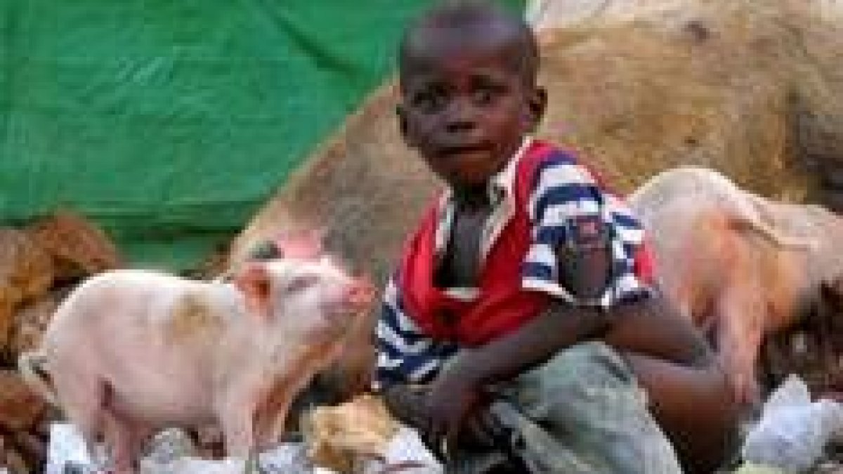 Un niño hace sus necesidades en un basurero de Sudán