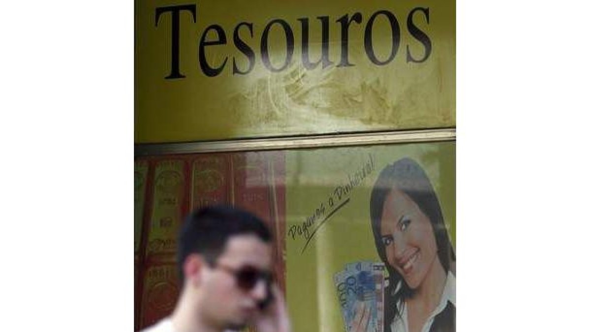 Un hombre pasa en Lisboa delante de una tienda en la que se compra oro.