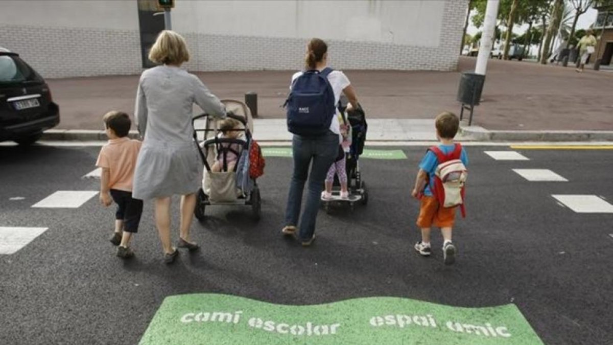 Madres con sus hijos, camino del colegio, en la Vila Olímpica.