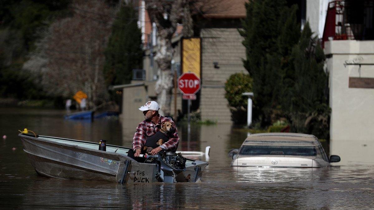 Pobladores intentan salir de una calle inundada en un poblado de California, EEUU.