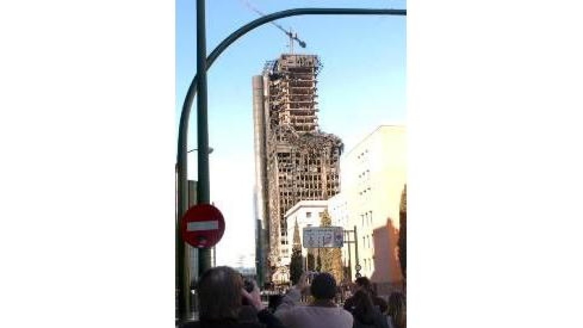 Varios curiosos fotografían el edificio siniestrado el sábado