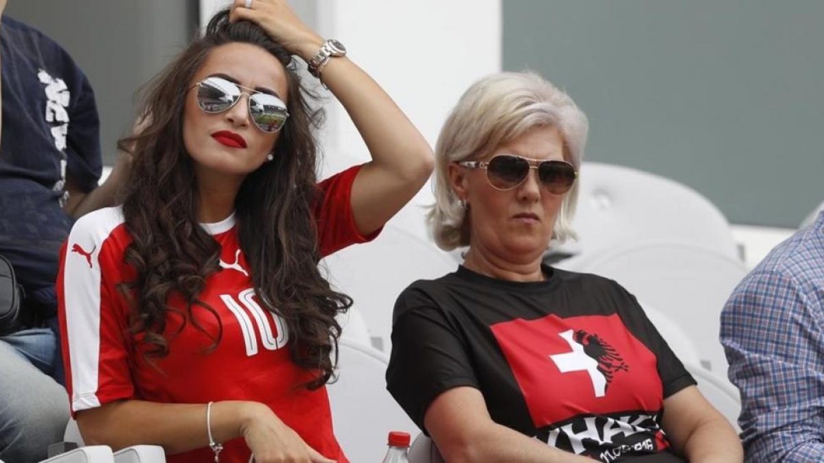 La madre de los hermanos Xhaka, con una camiseta dividida con los colores suizos y albaneses, junto a la pareja del suizo Granit.