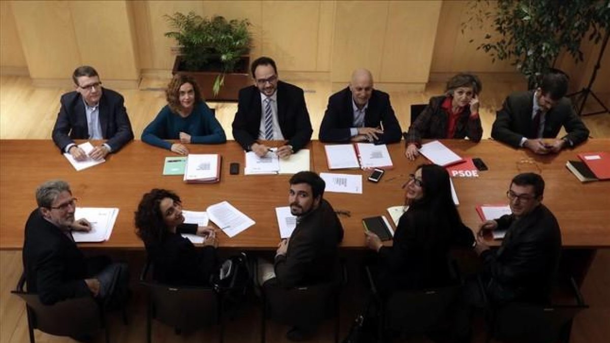 Los equipos negociadores de PSOE y de IU-Unidad Popular para la investidura de Pedro Sánchez este lunes, en su cita en el Congreso