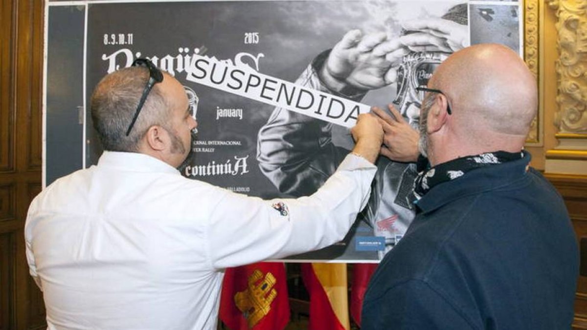 Participantes del club Turismoto, ponen el cartel de «suspendida» al cartel original de la próxima edición de la famosa concentración motera.