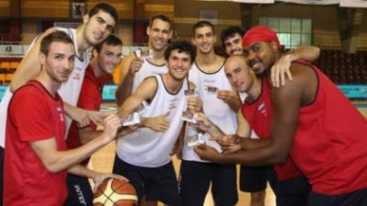 Los jugadores del baloncesto León exhiben sus carnets de socios.