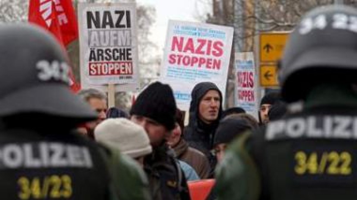 Activistas de izquierdas permanecen ante un cordón policial en Dresde.