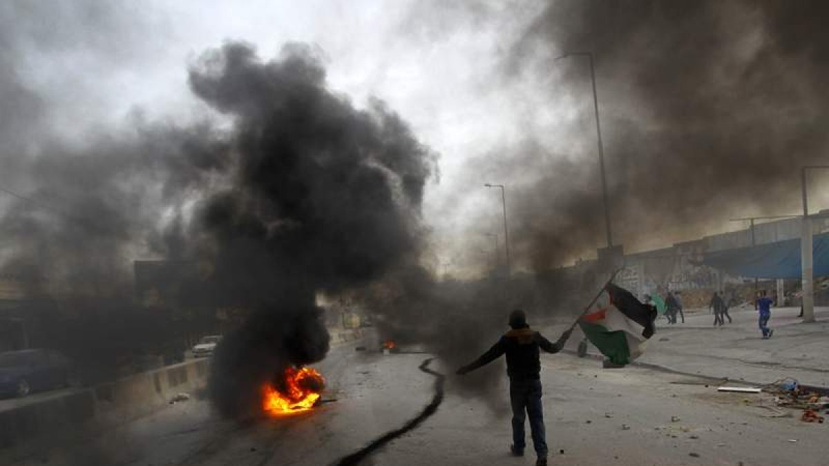 Un palestino pasa junto a una de las explosiones que han tenido lugar en Gaza.
