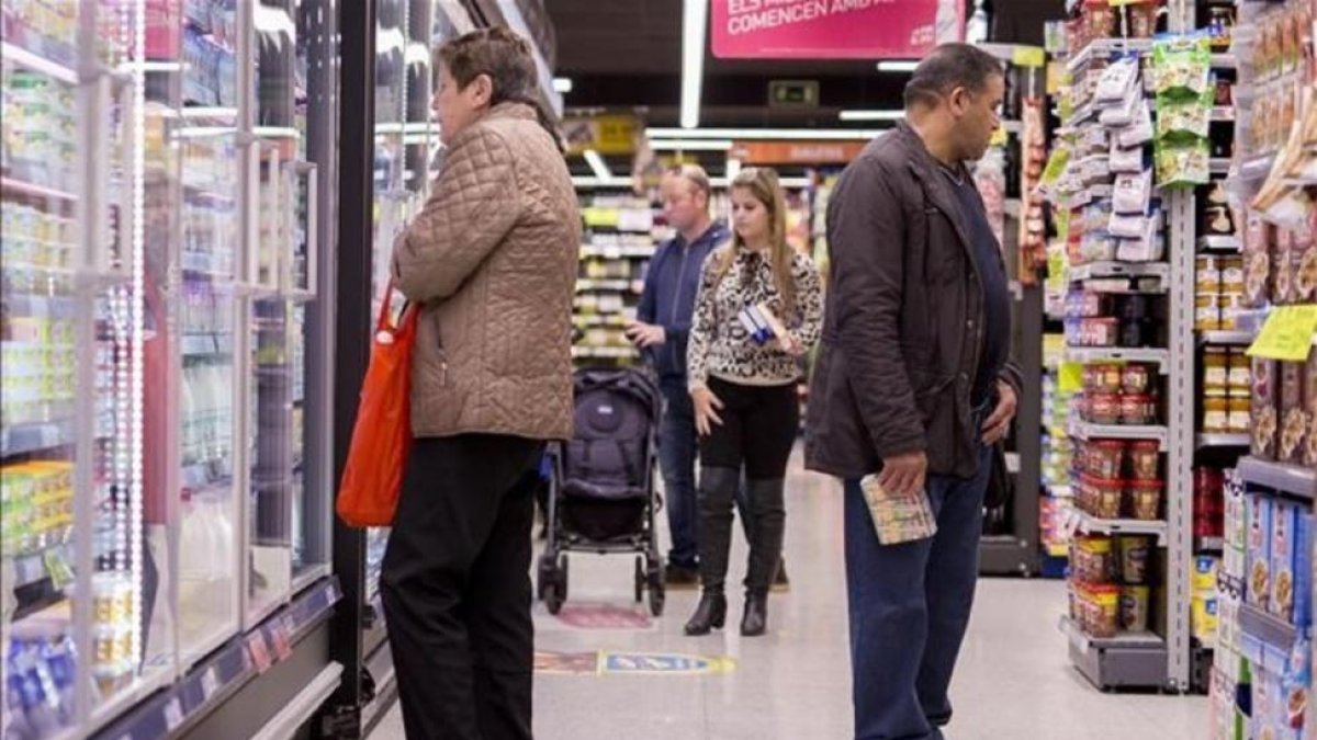 Un grupo de personas comprando en un supermercado en Barcelona.
