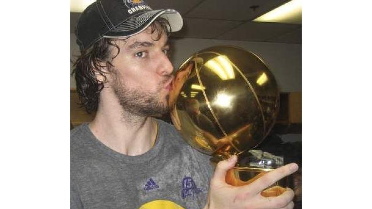 Pau Gasol besa el trofeo de campeones de la NBA.