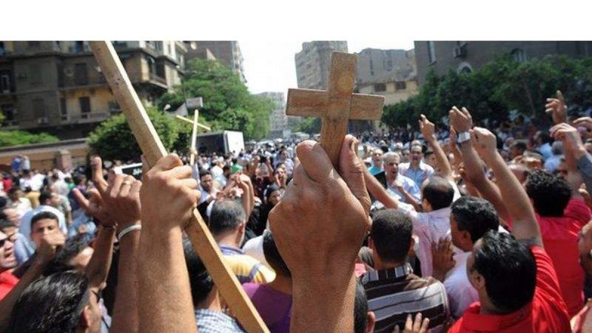 Centenares de personas protestan durante el funeral por los coptos fallecidos el domingo en los choques contra militares en el centro de El Cairo.