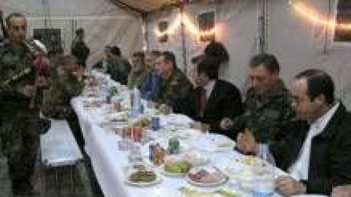 Un soldado toca la gaita ante Bono durante la comida celebrada ayer en el campamento de Arja