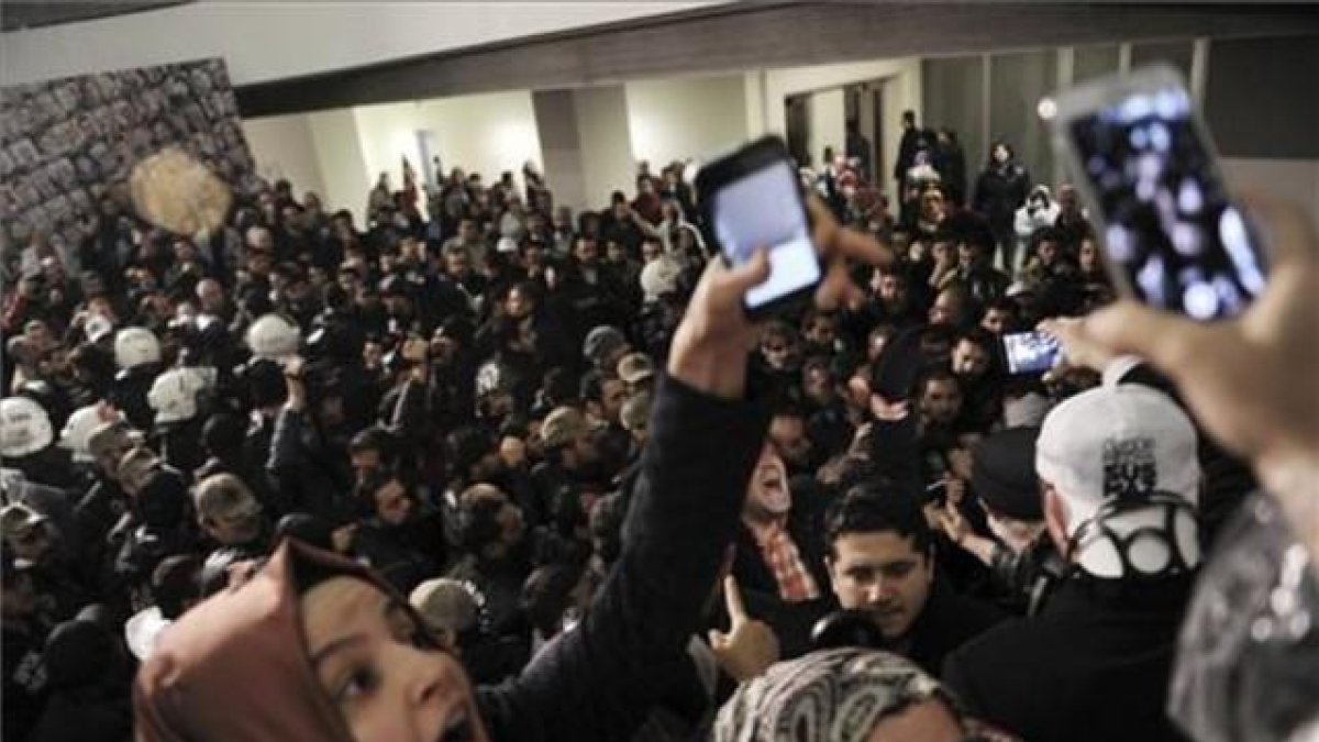 Un grupo de periodistas reaccionan ante el asalto de los antidisturbios en al sede del diario 'Zanan', es Estambul.