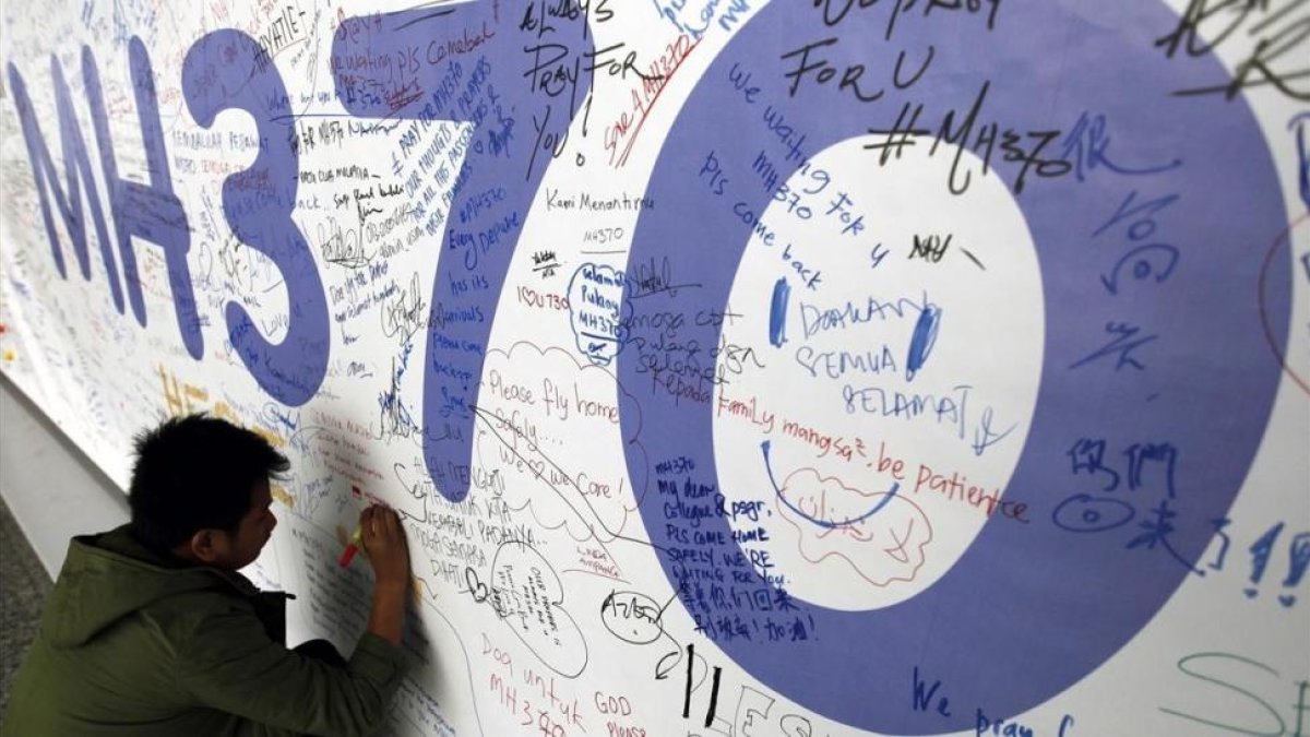 Un hombre escribe sus condolencias por las víctimas del vuelo MH370 de Malaysia Airlines en el aeropuerto internacional de Kuala Lumpur en marzo del 2014.