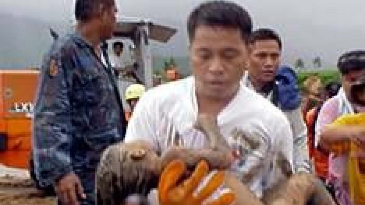 Un miembro de un equipo de rescate traslada a una víctima de la avalancha de lodo en San Bernardo