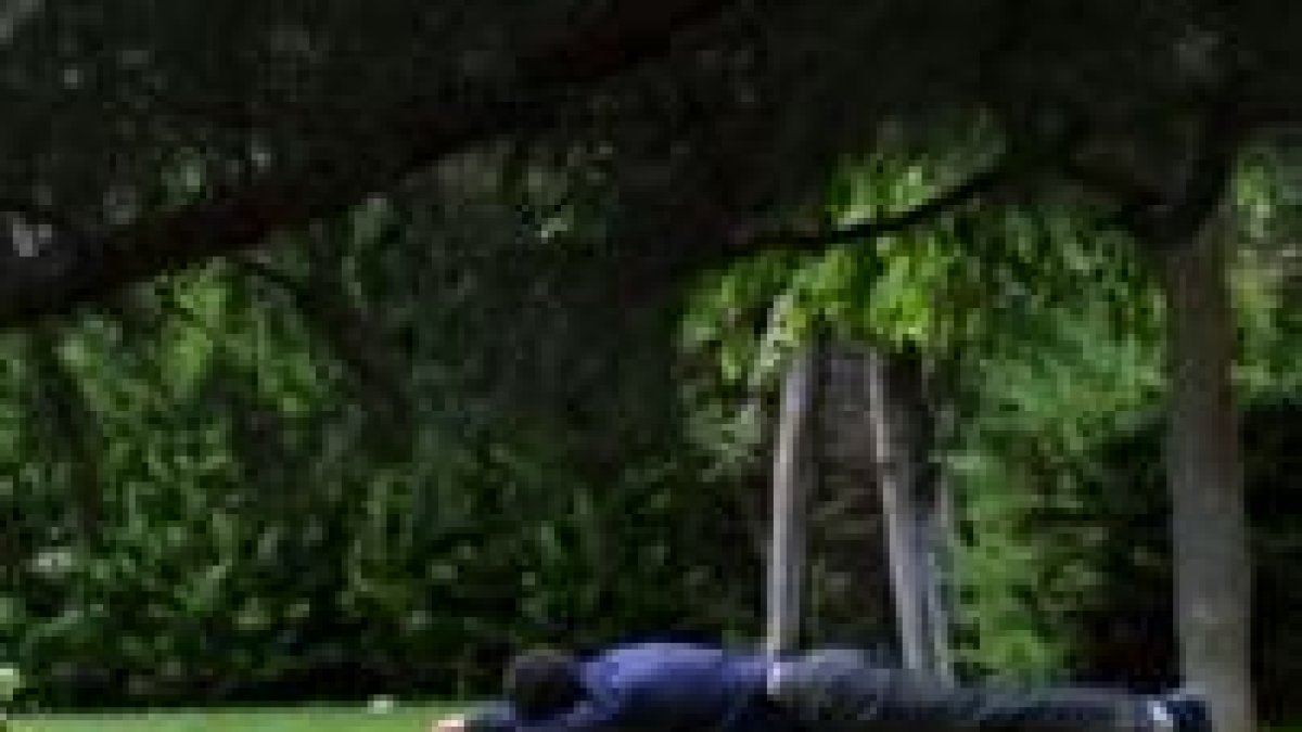 Unos jóvenes descansan en un parque de León