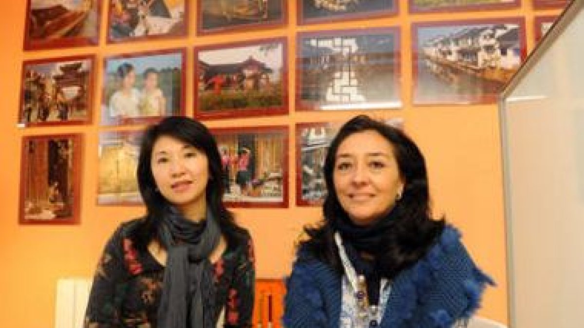 Anmei Xu y Julia Martínez con las fotos de China al fondo.