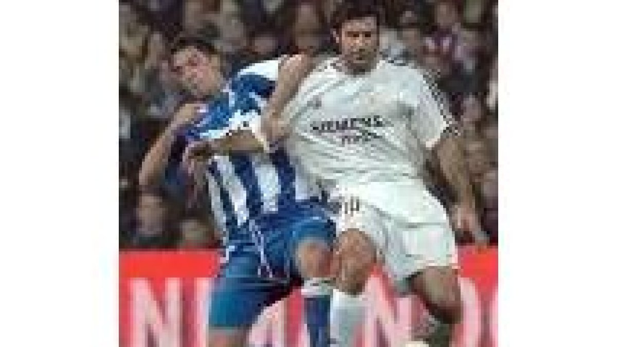 El deportivista Capdevila y el portugués Luis Figo pugnan por el control de un balón
