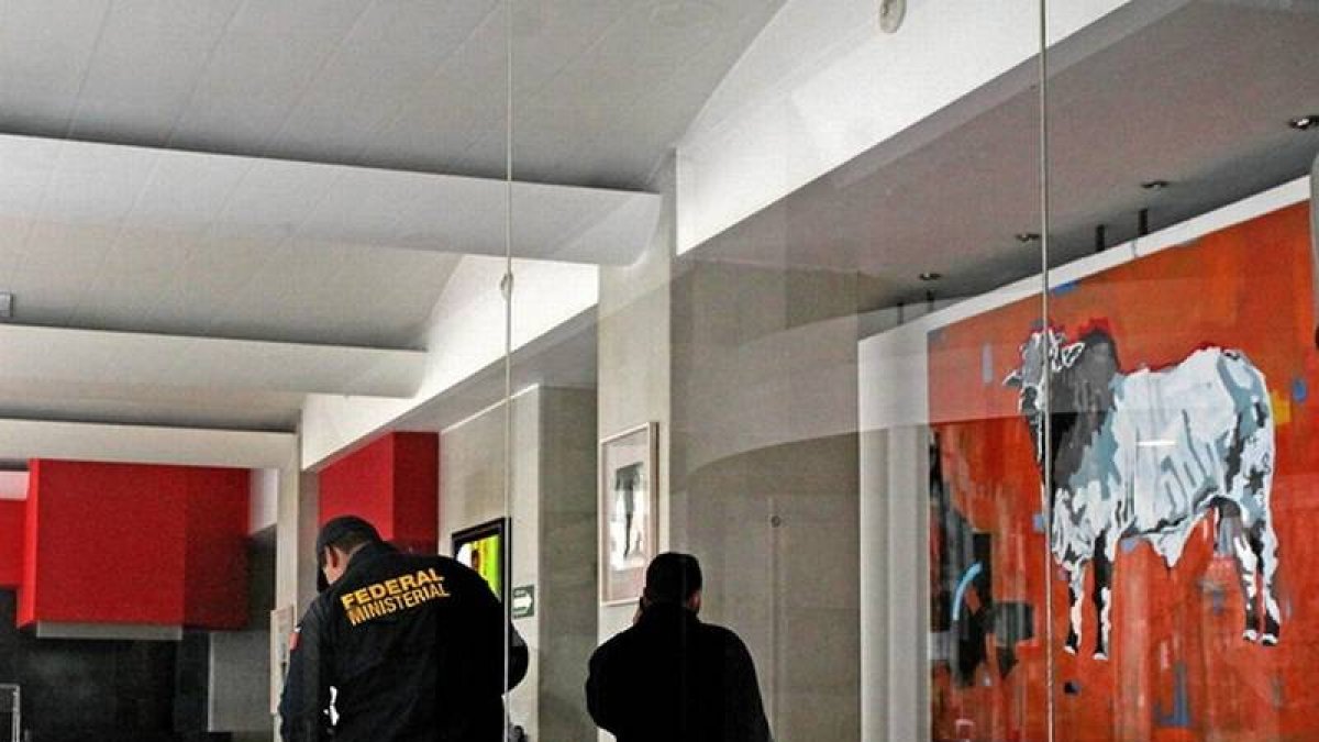 Policías mexicanos recogen pruebas en el hotel donde estaban secuestrados los integrantes de Delorean, el martes.