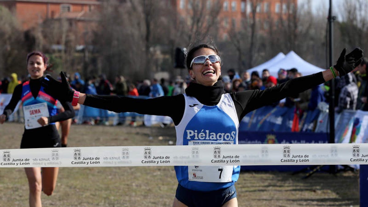 Nuria Lugueros levanta los brazos como triunfadora en el Cross Internacional de Valladolid. MONTSE ÁLVAREZ