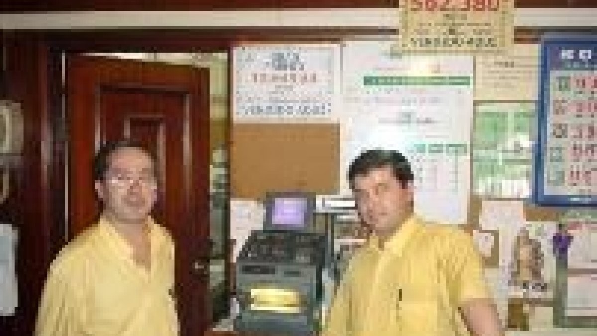 Los camareros del Restaurante Central de Boñar posan ante la máquina que selló el boleto