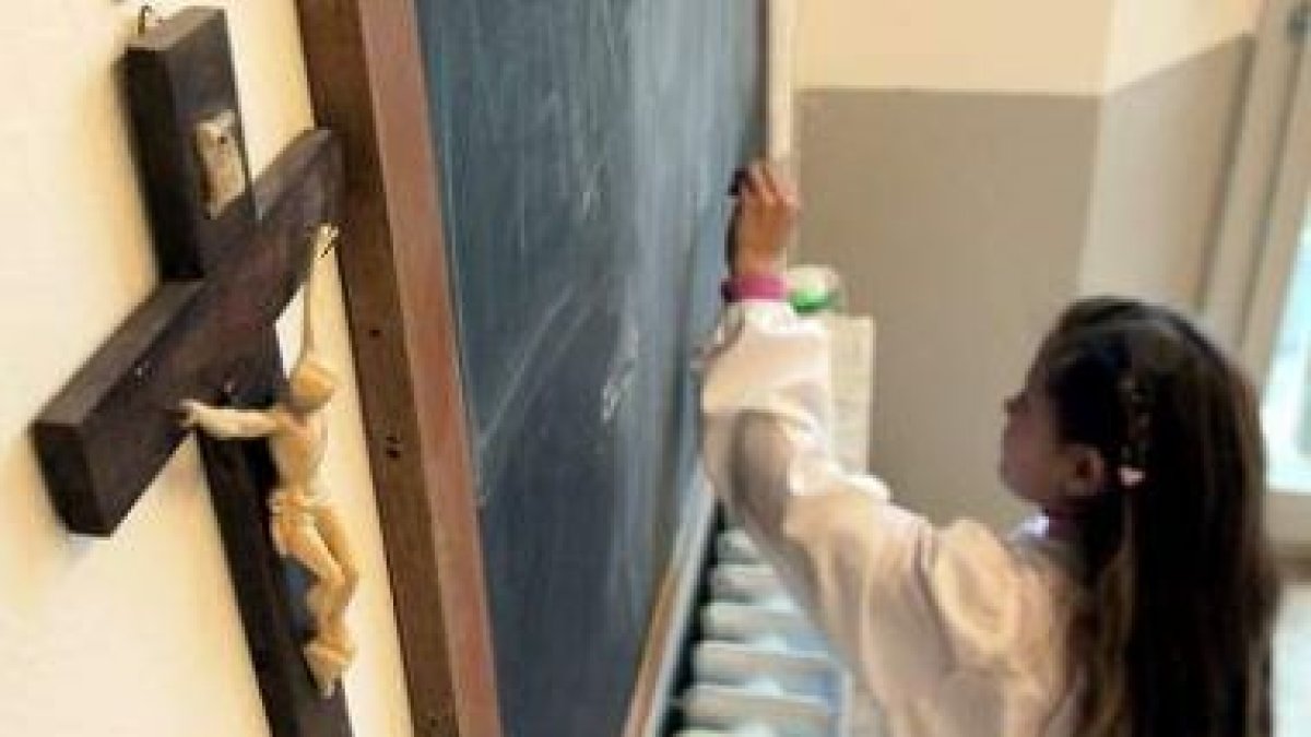 Una estudiante en una clase adornada con un crucifijo en un colegio de Pisa (Italia).