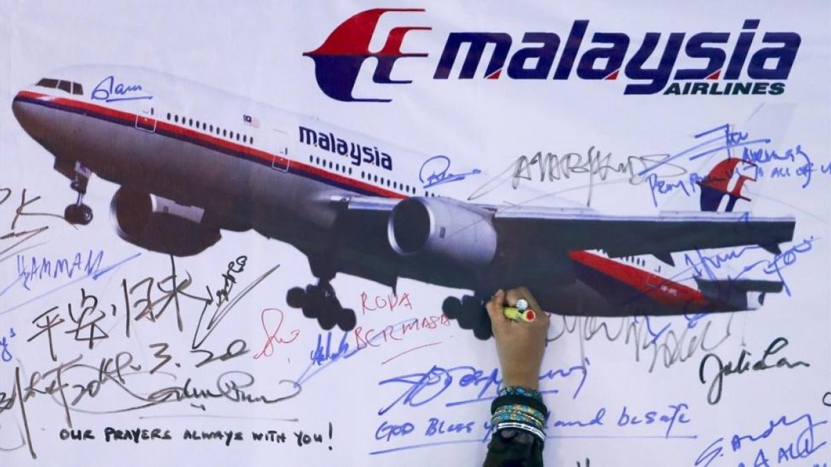 Una mujer escribe un mensaje de solidaridad con los pasajeros del vuelo desaparecido de Malaysia Airlines en Kuala Lumpur en el 2014.