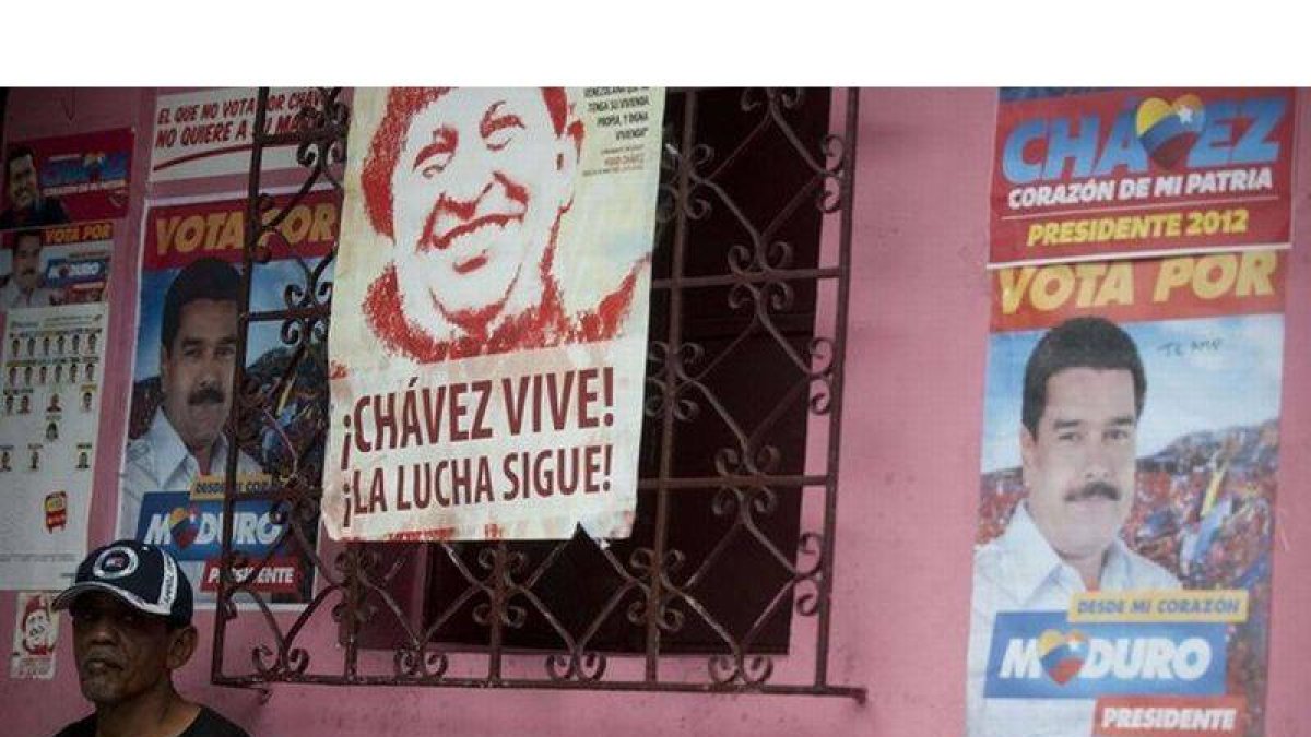 Un cartel con la imagen del fallecido Hugo Chávez junto a otro de su heredero político, Nicolás Maduro, este sábado en Caracas.