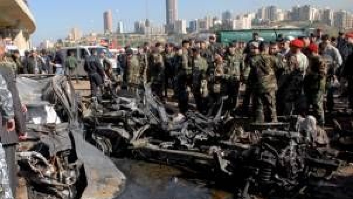 Grupos de policías libaneses observan el estado del coche empleado para el atentado terrorista