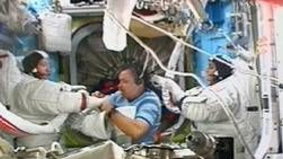 El ruso Mikhail Tyurin ayuda a López Alegría y a Willians con los trajes para su «paseo espacial»