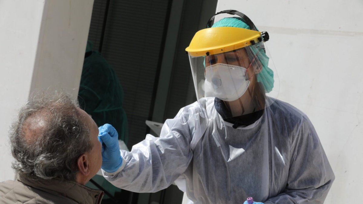 Profesionales sanitarios protegidos con batas, máscaras y guantes, efectúan pruebas para detectar el coronavirus. EFE