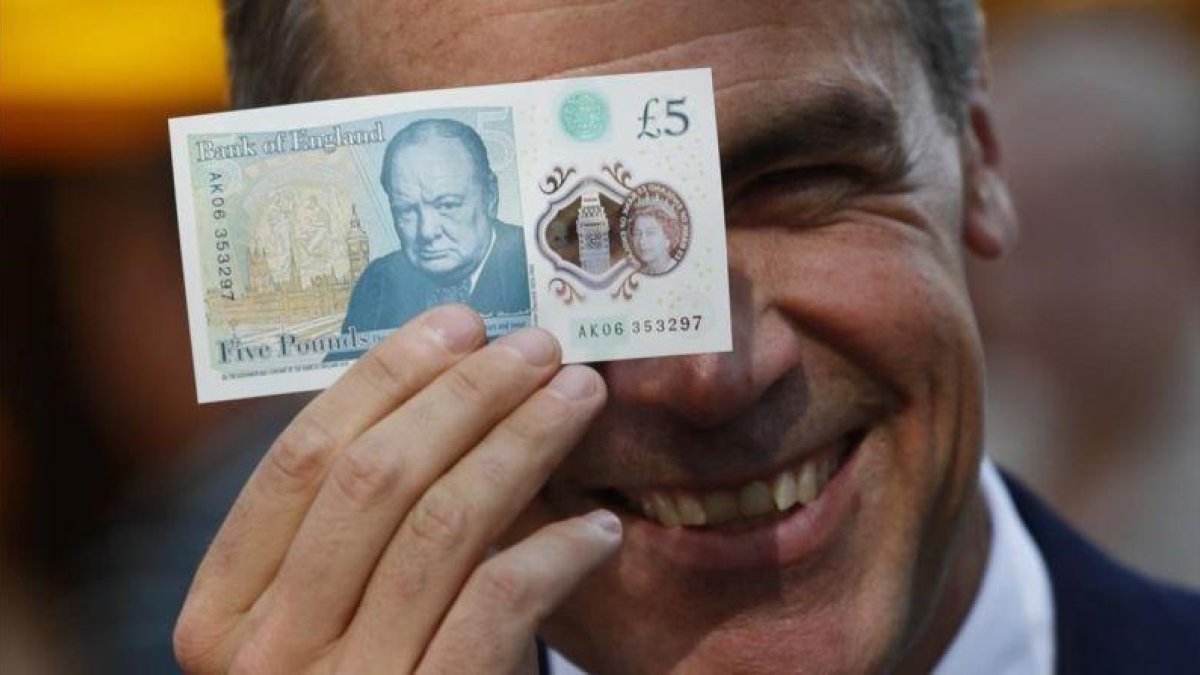 El gobernador del Banco de Inglaterra, Mark Carney, muestra el nuevo billete de plástico de 5 libras.