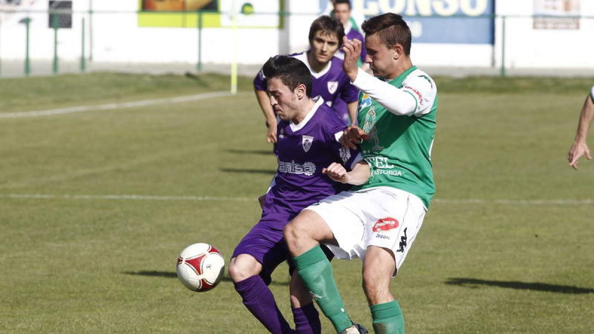 José Carlos, a la derecha, pugna por un balón con el jugador del equipo palentino Guille.