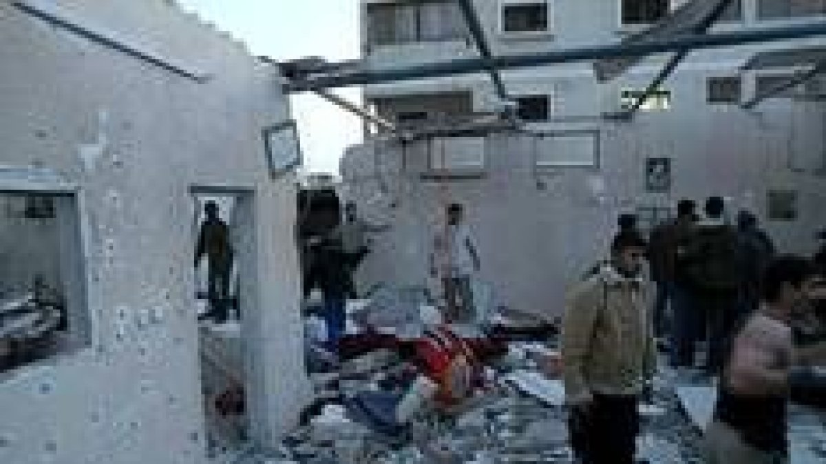 Un grupo de palestinos entre los escombros de la vivienda que fue atacada con misiles israelís