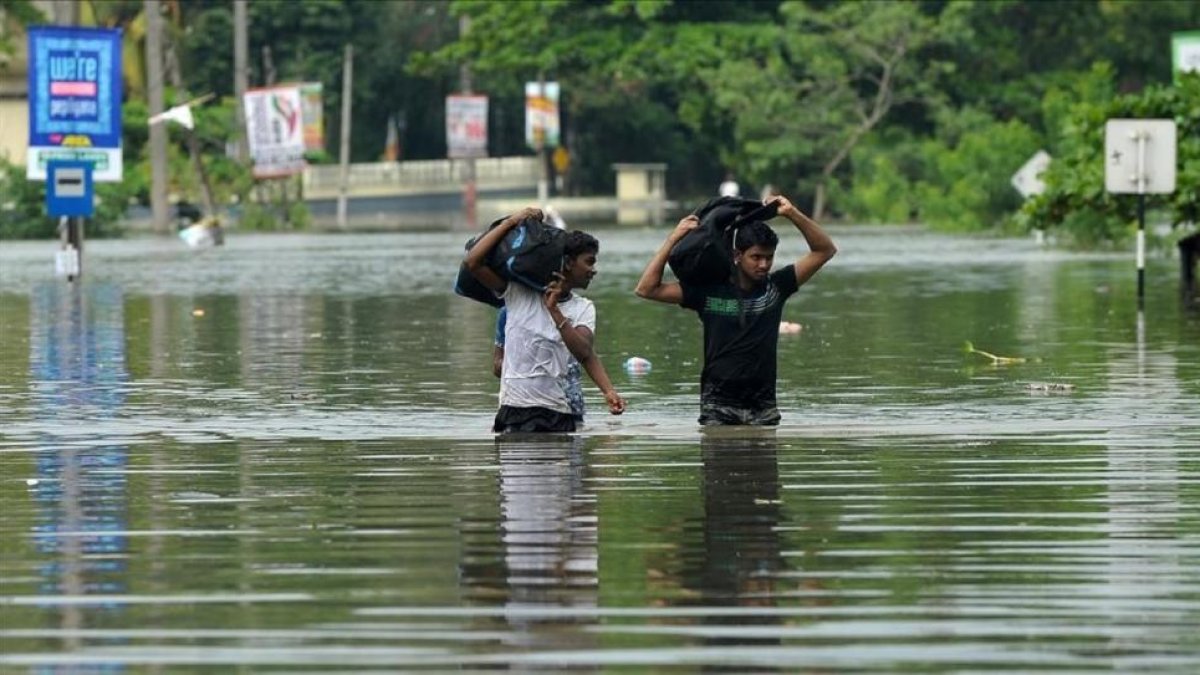 Dos jóvenes caminan entre las aguas a unos 17 kilómetros de la capital de Sri Lanka, Colombo.