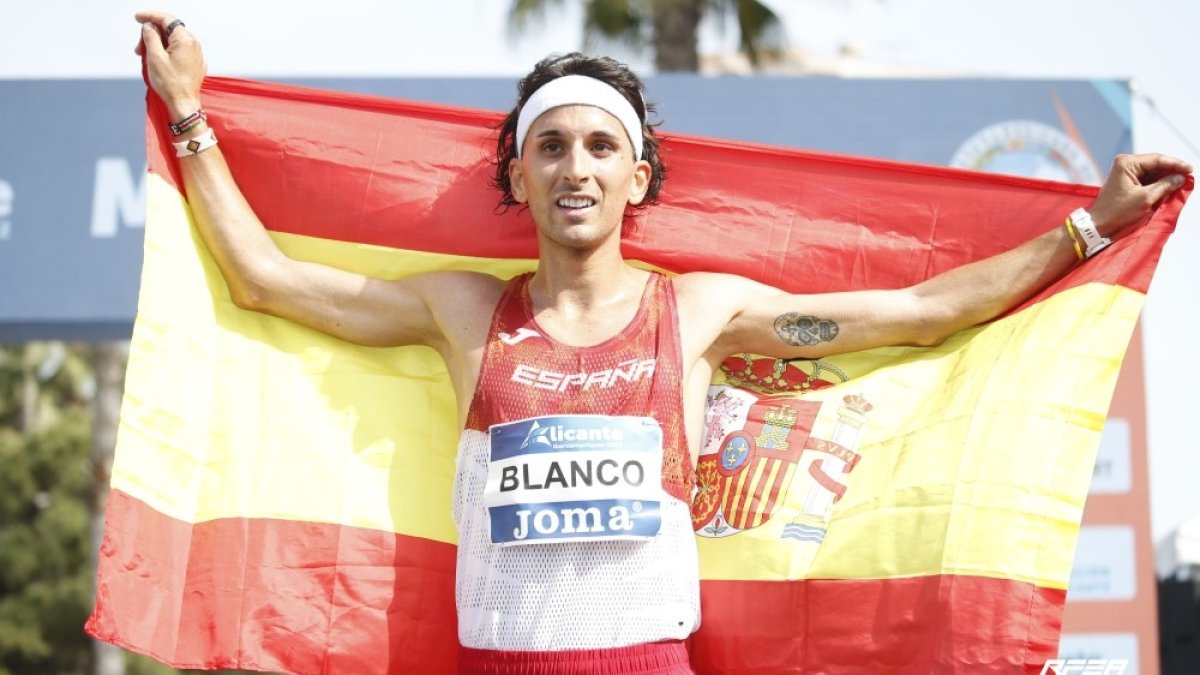 Jorge Blanco con la bandera de España tras cruzar en tercera posición en la línea de meta. 
Foto RFEA