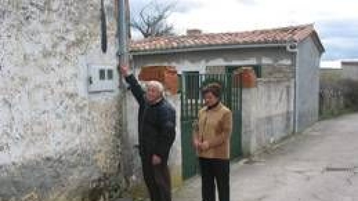 Dos miembros de la junta vecinal muestran uno de los interruptores para encender la luz pública