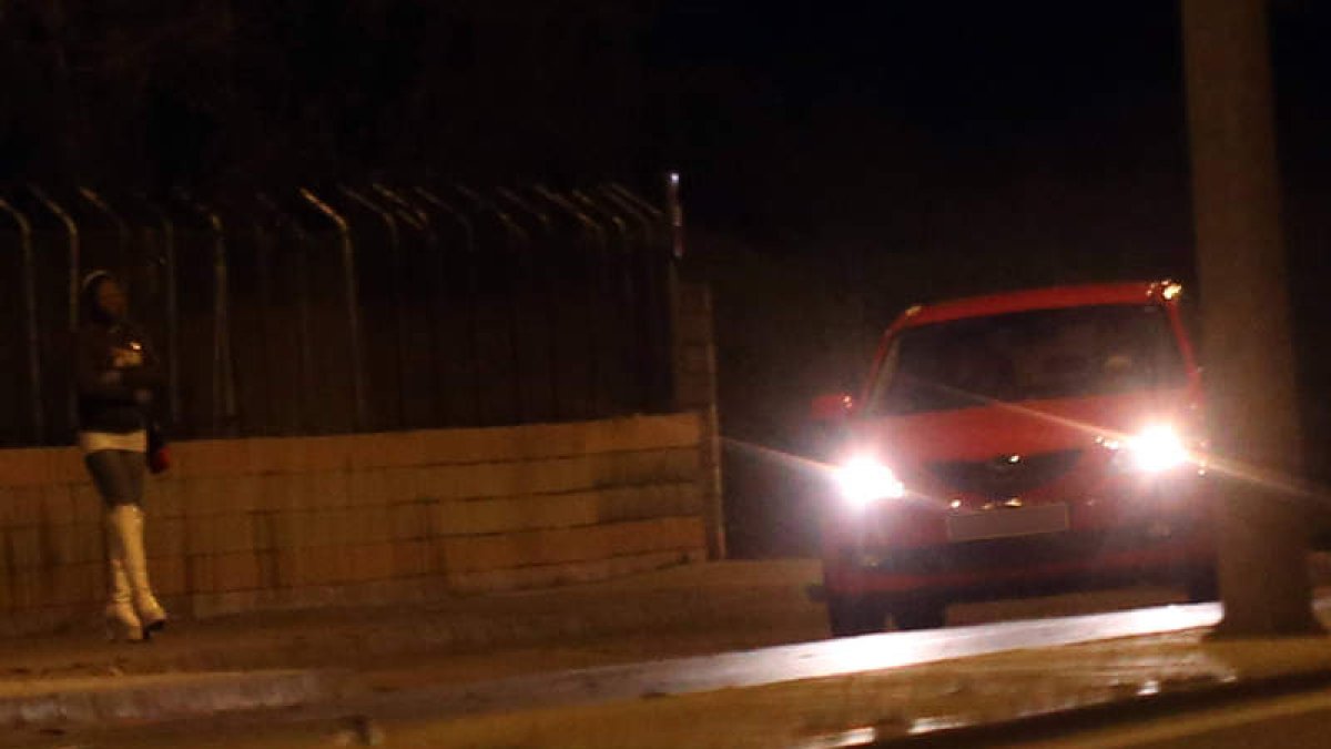 Una profesional del sexo de pago espera mientras un vehículo circula por la glorieta cercana a la avenida de Sáenz de Miera en la capital.