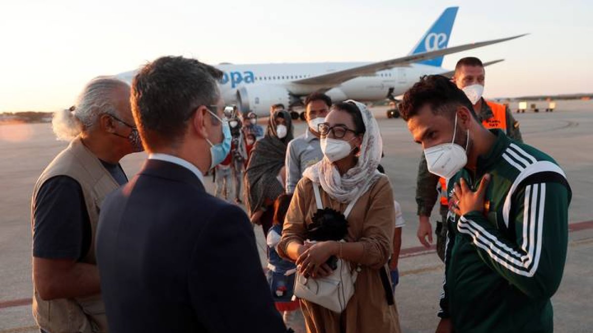 El ministro de la Presidencia, Félix Bolaños (2i), da la bienvenida a la jugadora afgana de baloncesto en silla de ruedas Nilofar Bayat (c) y a su marido (d) en la base aérea militar de Torrejón de Ardoz (Madrid), donde hoy viernes ha aterrizado el segundo avión fletado por España para evacuar a españoles y afganos del país asiático con 110 personas, entre ellas tres familias completas de personal de la Embajada. EFE/Mariscal POOL