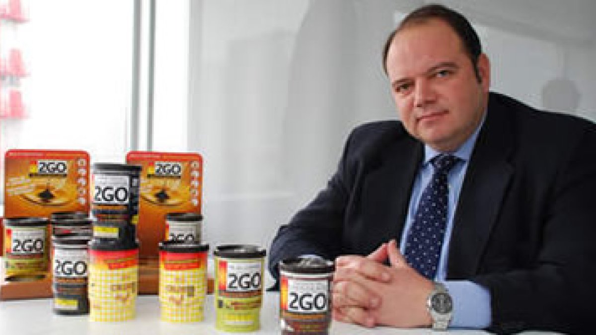 Javier Gil, administrador de Fast Drinks, junto a un lote de los productos fabricados en Villarejo.