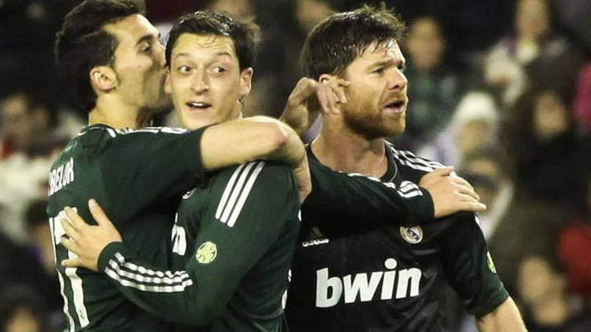 Mesut Özil celebra su primer gol, el segundo de su equipo, junto a Arbeloa y Xabi Alonso.