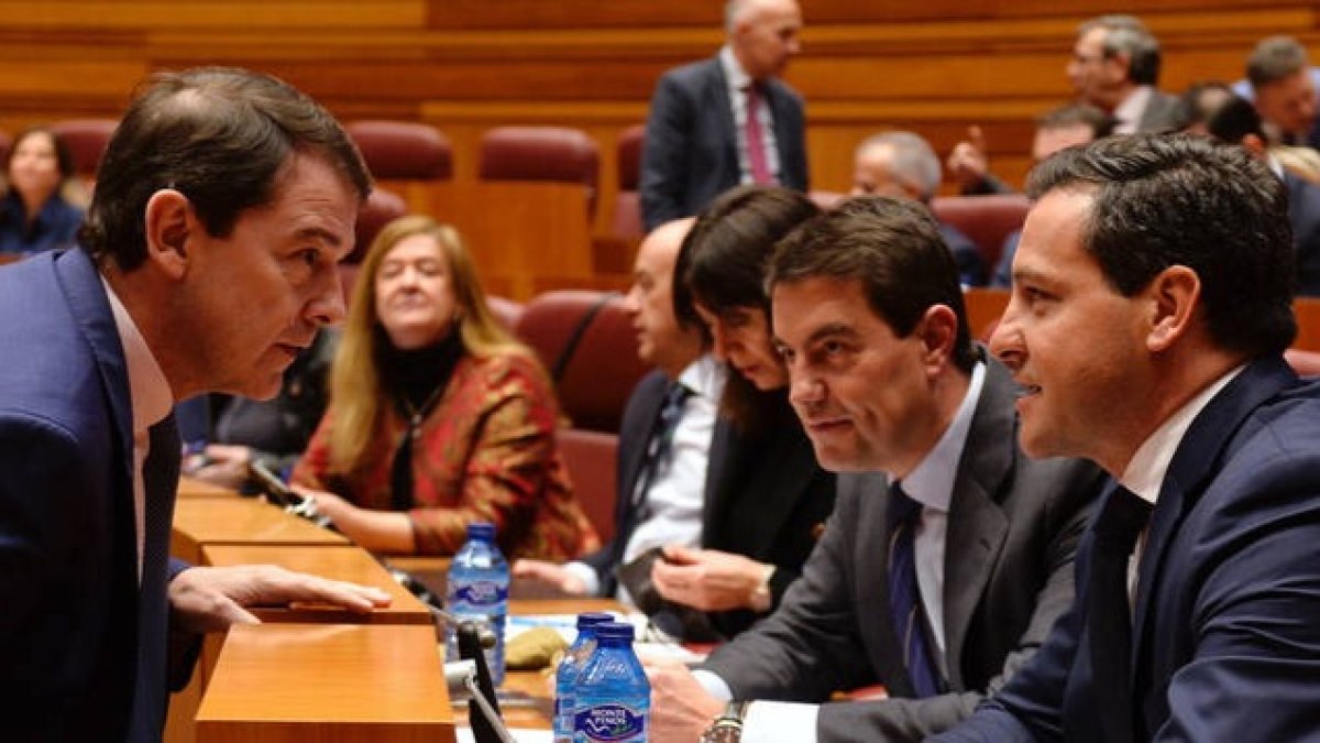 El presidente de la Junta de Castilla y León, Alfonso Fernández Mañueco (i), conversa con los viceportavoces del Grupo Parlamentario Popular, Raúl de la Hoz (d) y Ángel Ibáñez (2d), al inicio del debate. NACHO GALLEGO