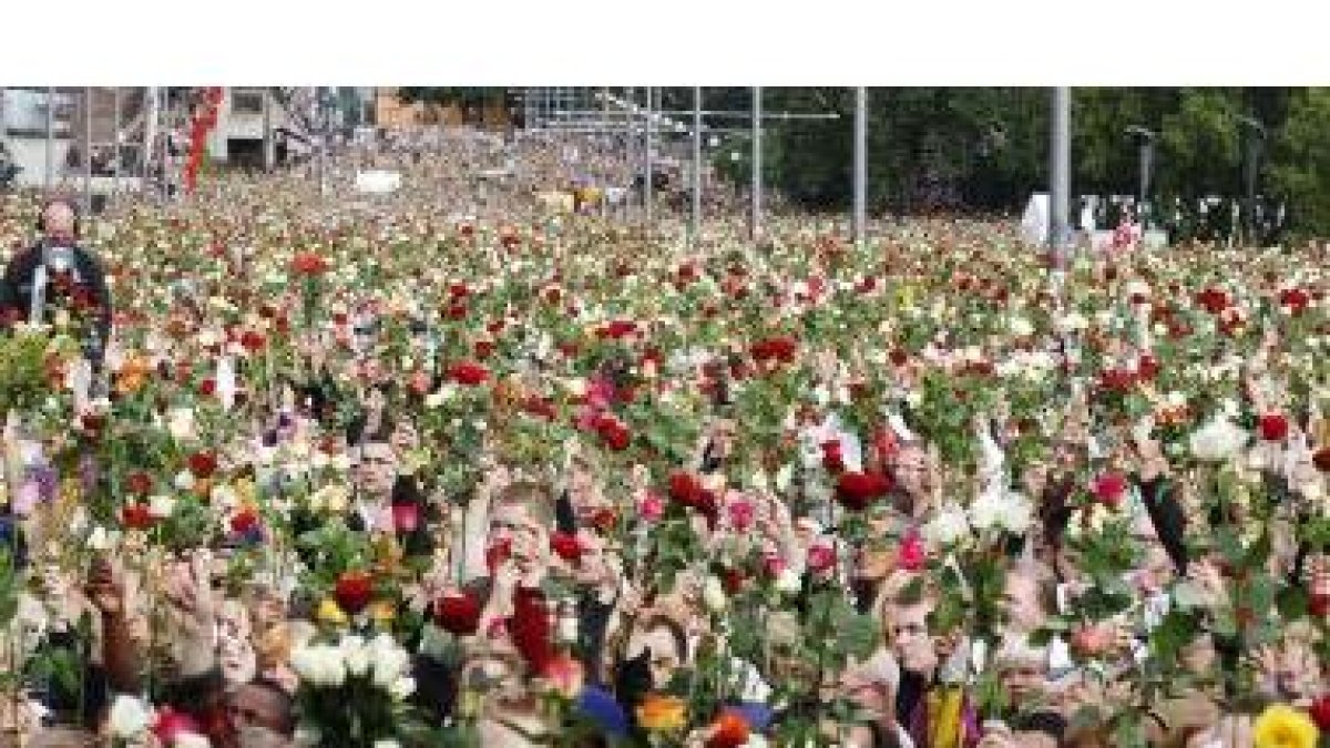 Miles de personas muestran sus rosas en la marcha de ayer.