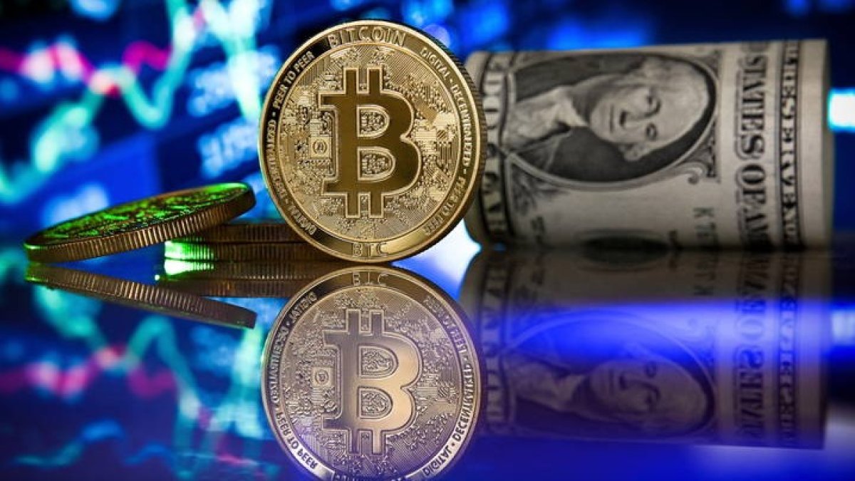 Fotografía de archivo fechada el 20 de enero de 2021 que muestra un bitcoin junto a un fajo de dólares. EFE