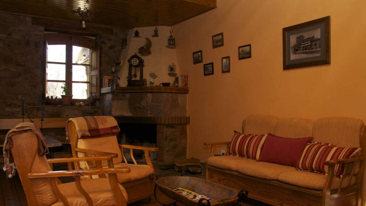 Salón con chimenea, patio, zonas de comedor y dormitorio dela posada El Embrujo,en Pobladurade la Tercia.