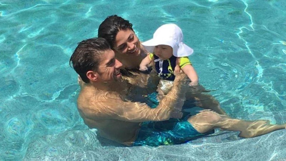 Michael Phelps, con su pareja, Nicole Johnson, y su hijo, Boomer, en la piscina.
