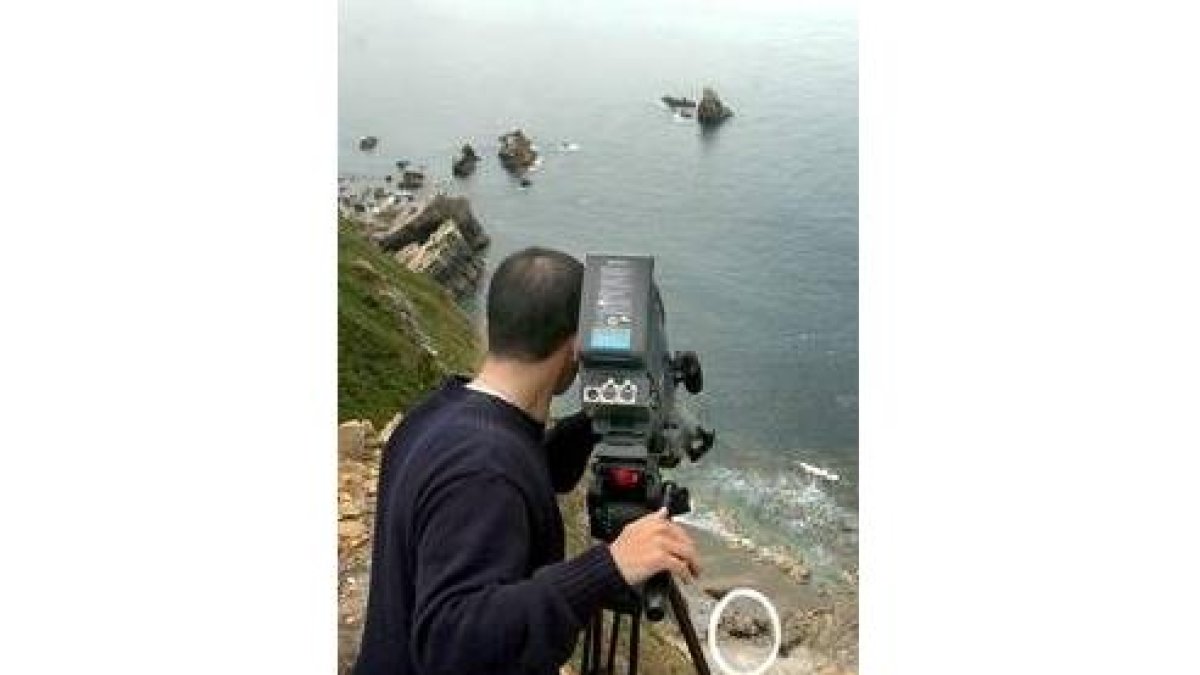 Un cámara toma imágenes del coche en el fondo del precipicio