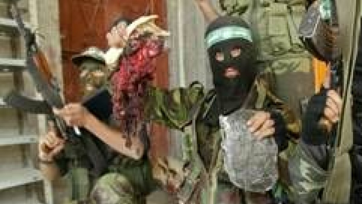 Enmascarados palestinos muestran un trozo del cadáver de un soldado israelí muerto en Gaza